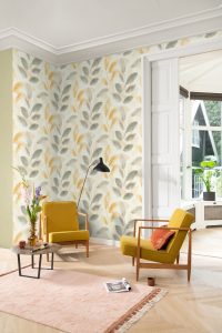 Papel mural non-woven lavable para interiores con un diseño de hojas delicadas en tonos gris y amarillo, con efecto acuarela.